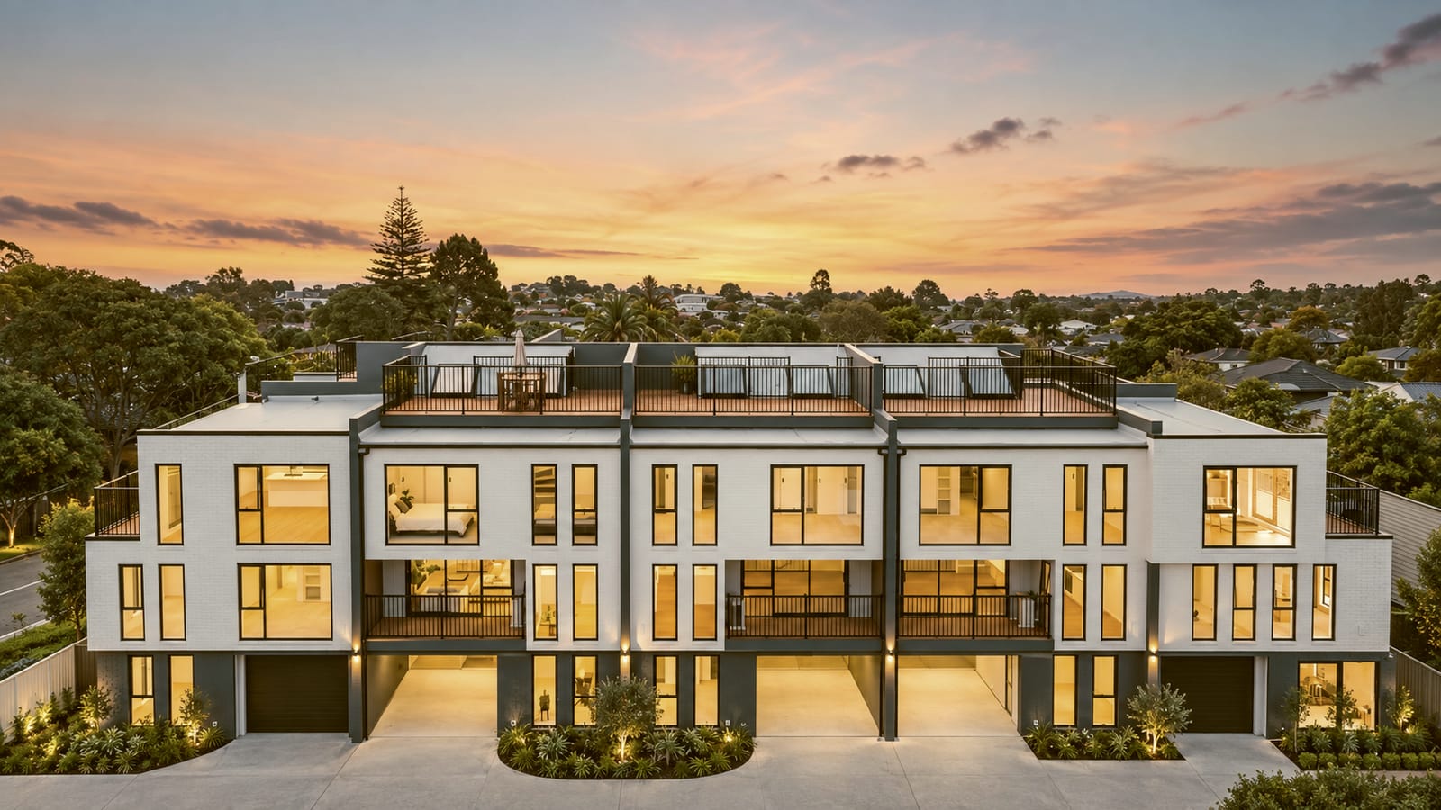 Contemporary Auckland townhouses at dusk, windows lit, delivered under the management of the Molotok team