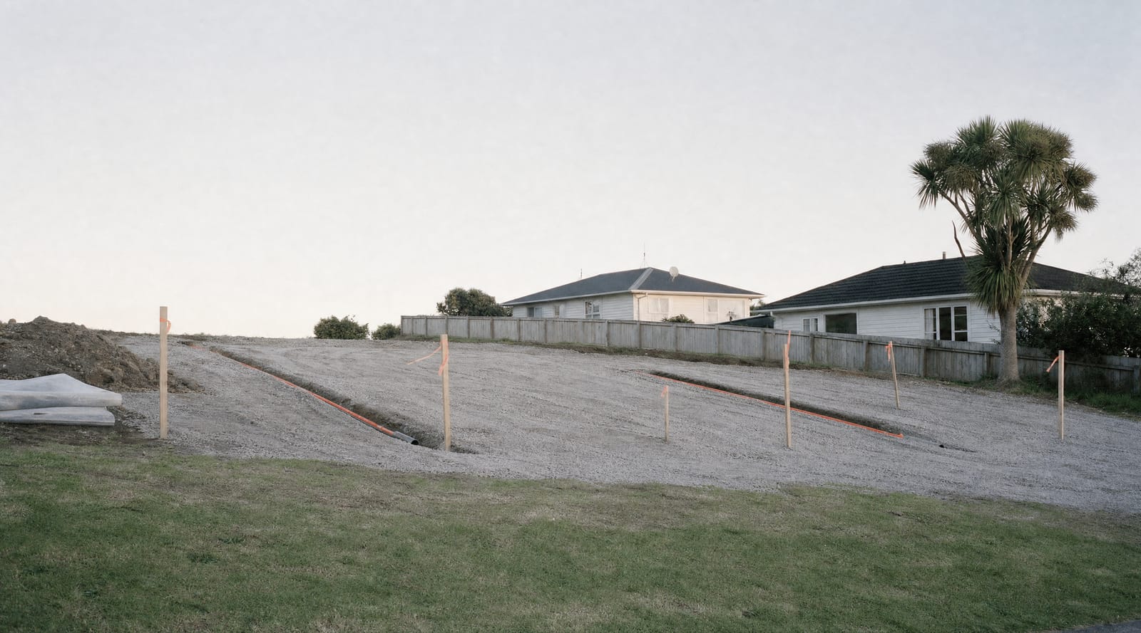 Levelled building platform with service trenches